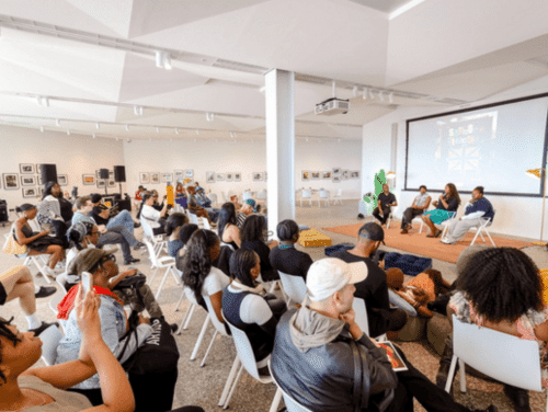 A crowd of people sat down attending a talk