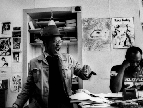 Black and white image of Adrian Boot, ‘Linton Kwesi Johnson and Darkus Howe at the Race Today office
