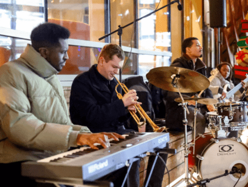 A jazz band performing outside in winter coats