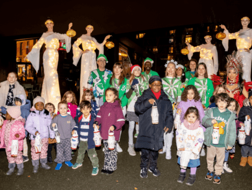 Performers in stilts pose with families and children