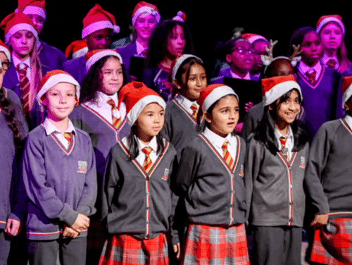 Children in a choir with red christmas hats