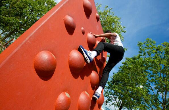A climber gets to the top of a climbing wall 