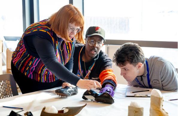 Students and teachers lean over a desk at East Careers Week