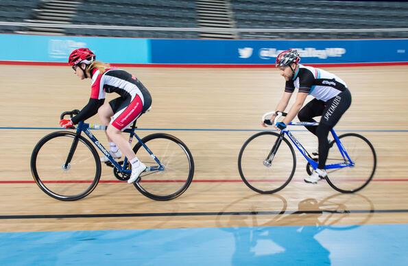 Two people cycling indoors at the VeloPark