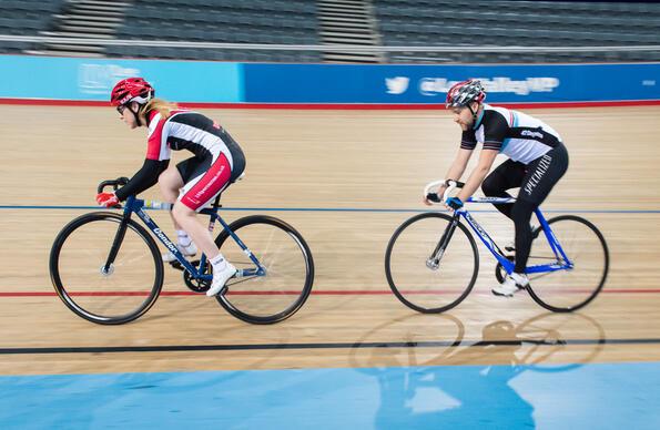 Two people cycling indoors at the VeloPark Two people cycling indoors at the VeloPark