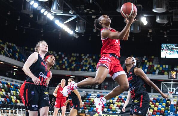 A basketball player jumps to dunk the ball