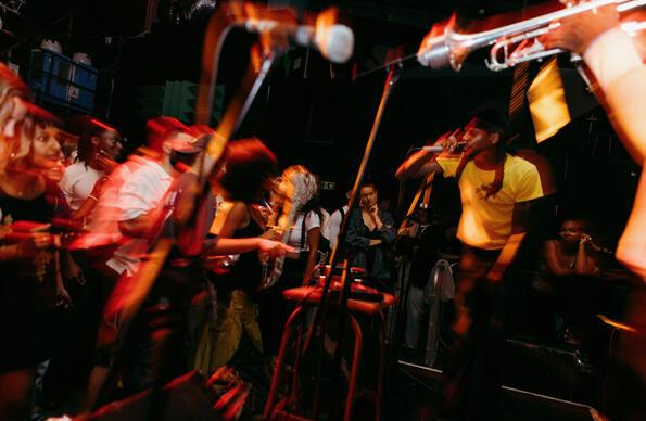 A group of people dance and play instruments