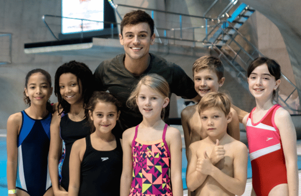 Children posing for a photo with Tom Daley