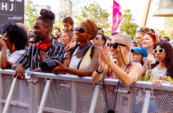 A crowd of people by some barriers at an event