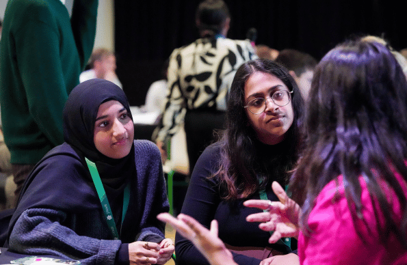 Two girls being talked to at an event