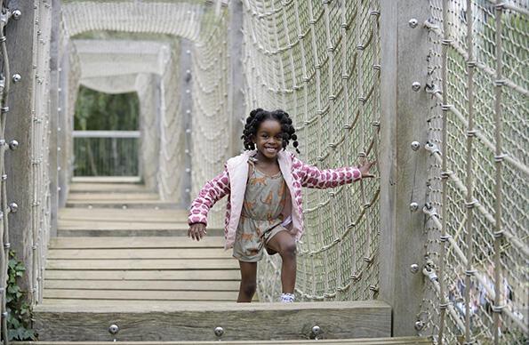 A girl runs across a play area of Tumbling Bay Playground