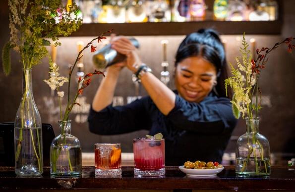 A bar person at Barge East mixes cocktails 