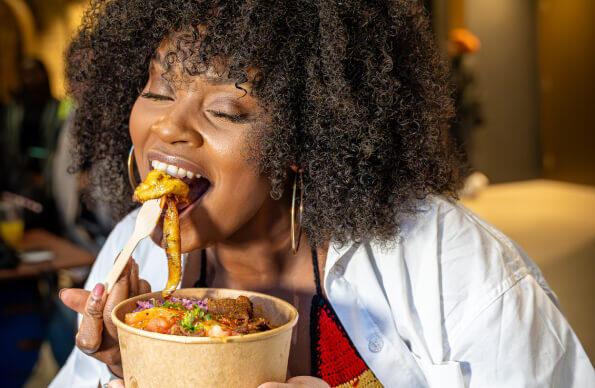 A person eats food at Black East Festival A person eats food at Black East Festival