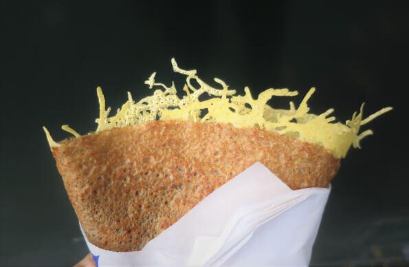 A cheese crepe wrapped in white paper A cheese crepe wrapped in white paper
