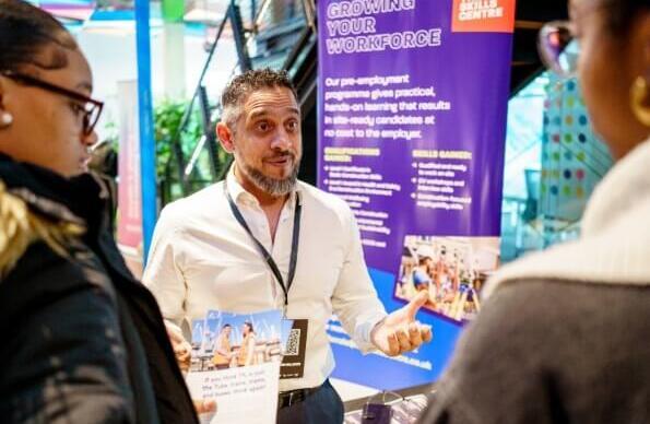 A man discussing with youths at a community engagement fair