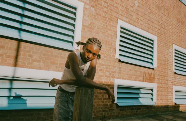 Flohio stands against a brick wall backdrop