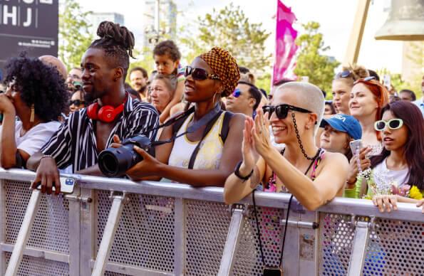 A crowd at Great Get Together leaning on a barrier and smiling