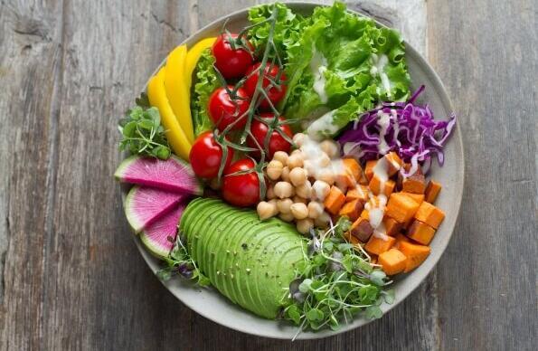 A vibrant salad with avocado, sweet potatoes, tomatoes and veg