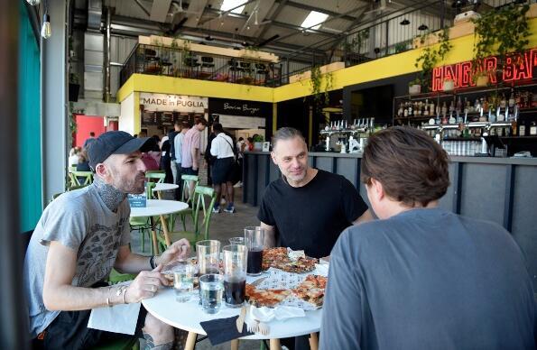Three men chatting and eating inside Hackney Bridge Three men chatting and eating inside Hackney Bridge