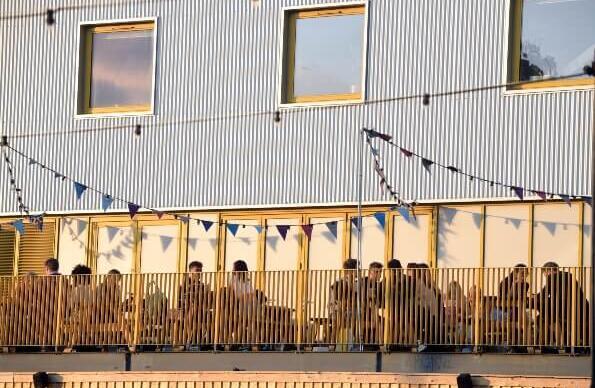 People dining on the terrace outside Hackney Bridge in the evening People dining on the terrace outside Hackney Bridge in the evening
