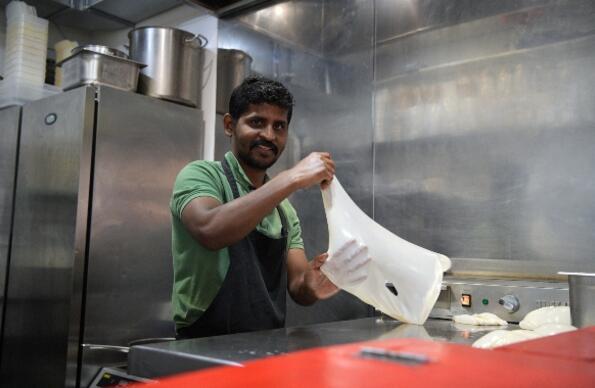 A cook preparing food at Hackney Bridge