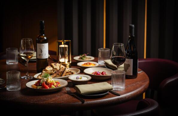 A table of plated food featuring red wine A table of plated food featuring red wine