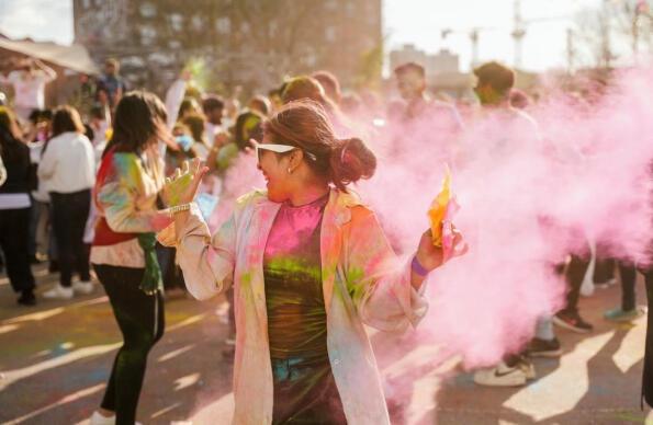 People celebrate Holi with colours in the air