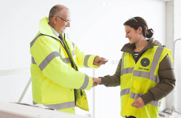 A male and female construction worker shaking hands