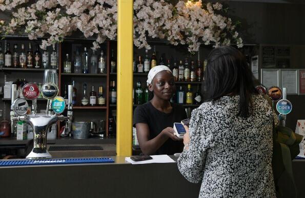 A hospitality worker accepting a patron's payment at the bar of the Last Drop cafe A hospitality worker accepting a patron's payment at the bar of the Last Drop cafe