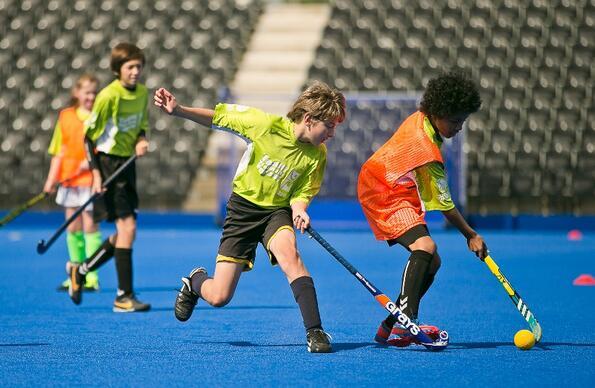 Children playing in a hockey match at the centre Children playing in a hockey match at the centre