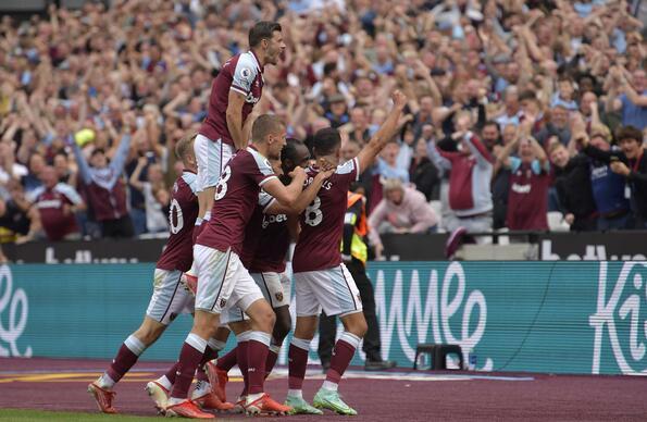 West Ham players celebrating on the pitch at London Stadium after scoring a goal
