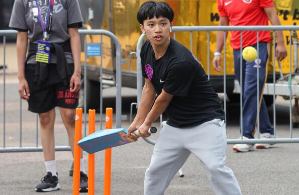 A young person plays cricket A young person plays cricket