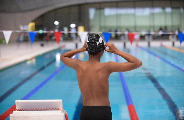 A swimmer preparing to enter the pool A swimmer preparing to enter the pool