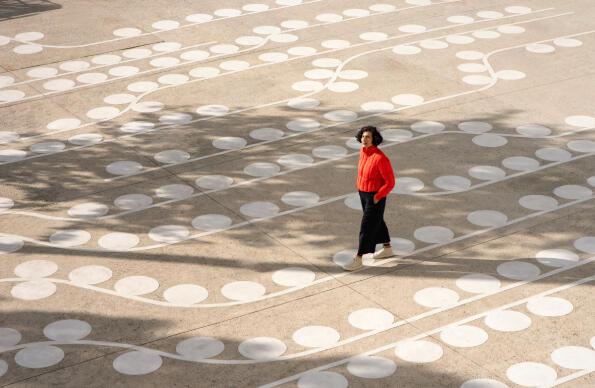 Artist Lubna Chowdhary walks across her artwork Temporal Trace