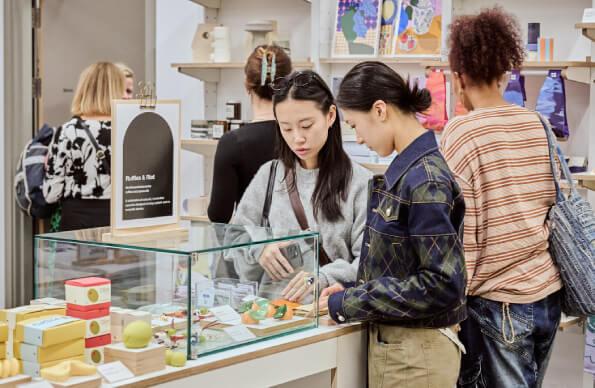 People look into a display case at not just a shop