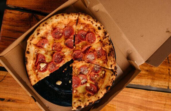 A pizza in a takeaway box