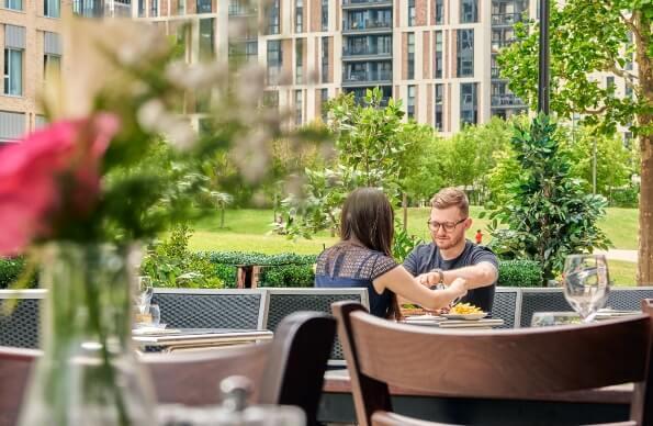 A couple enjoying food on a restaurant terrrace A couple enjoying food on a restaurant terrrace