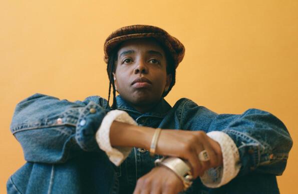 DJ Shy One sits with arms crossed looking at the camera