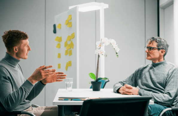 Two people talking at a desk