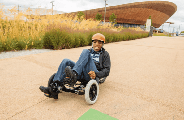 Boy riding an adaptive cycle