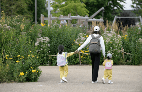 Woman walking with two small children