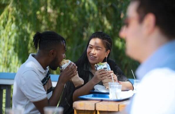 People eating souvlaki outside Taverna In the Park