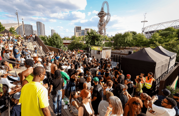 Mid Terrace at The Music is Black Festival filled with a large crowd dancing in the sunshine