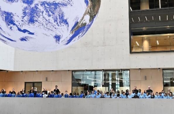 BBC Singers join with students from three East London schools around the Gaia globe artwork by Luke Jerram in UCL East campus’s Marshgate building