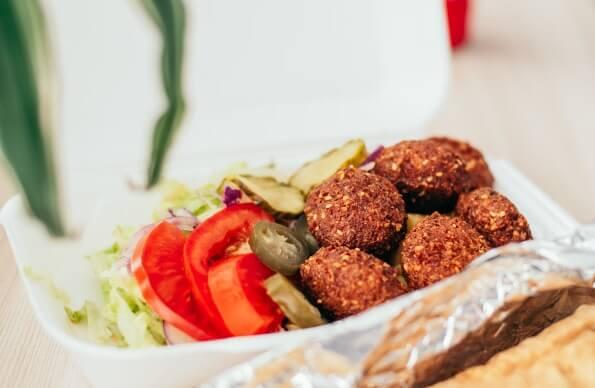 A falafel dish with pickles and tomatoes