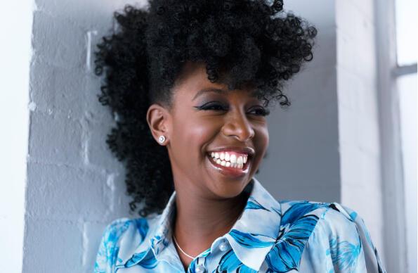 YolanDa Brown stands against a white brick wall