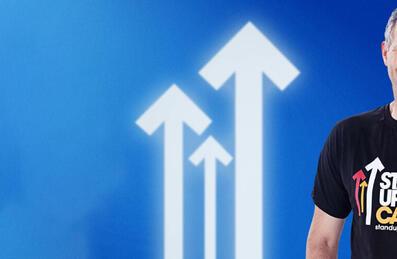 Prsenter Adam Hill stands in front of a blue background