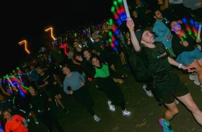 a group of runners with lights running in the dark