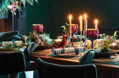 A table dressed for christmas with candles and trimmings