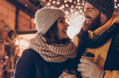 A couple in winter clothing and hot drinks